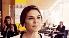 a woman is standing in front of a group of people in a room .
