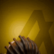 a person with dreadlocks holds a football in front of a yellow star