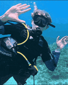 a man wearing a scubapro scuba diving suit is swimming in the ocean