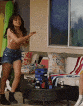 a woman in a bikini is dancing in front of a table with bottles of beer and a jenga board