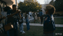 a man taking a picture of a girl wearing a warriors jacket