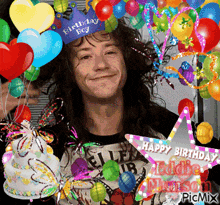a man wearing a birthday boy hat surrounded by colorful balloons