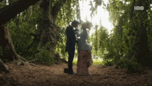 a man and a woman are standing under a tree with hbo written on the bottom