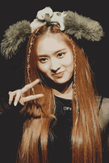 a girl wearing a headband with a stuffed animal on top of it