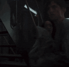 a woman is walking down stairs in a dark room .