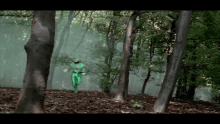 a person in a green costume is running through a forest
