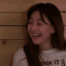 a woman wearing a white shirt that says ink it 's u is smiling