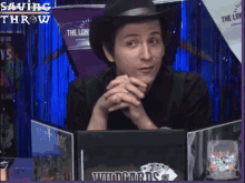 a man wearing a cowboy hat is sitting at a table with a saving throw sign in the background