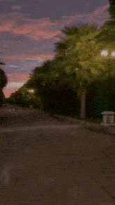 a car is driving down a road with a tree in the background