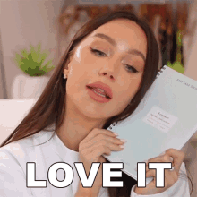 a woman is holding a notebook that says reminder on it