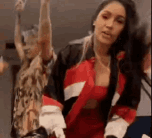 a group of women are dancing in a room with their hands in the air .