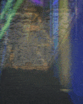a blurry picture of a cell phone with the letter t on the screen