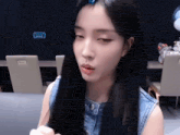 a woman with long black hair has a blue clip in her hair that says 9999