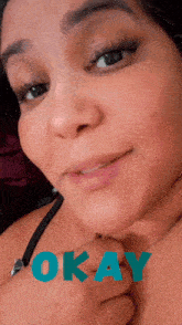 a close up of a woman 's face with the word okay in blue letters
