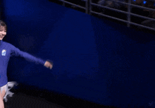 a person is doing a handstand in front of a blue wall