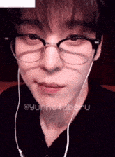 a close up of a person wearing glasses and headphones with the name yunho taberu on the bottom
