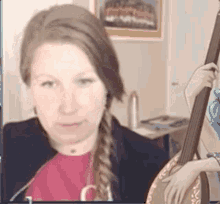 a woman is holding a banjo in front of a picture of a girl playing a banjo .