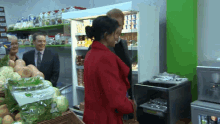a woman in a red coat stands next to a man in a suit