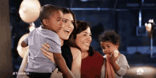 a woman is holding a child in her arms and smiling .