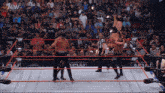 a wrestler is being lifted in the air by another wrestler in a aew wrestling ring