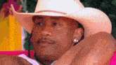 a man wearing a cowboy hat is laying on a couch