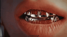 a close up of a person 's mouth with gold grills on it .