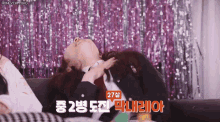 a woman is laying on a couch with a sign that says ' 27 ' on it .