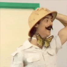 a man wearing a safari hat and a butterfly bow tie
