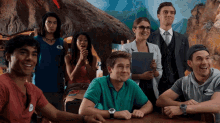 a group of people sitting around a table with one man wearing a name tag that says ' ariel ' on it