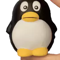 a person is holding a black and white penguin toy