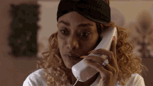 a woman talking on a phone with bet written on the bottom of her shirt
