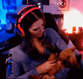 a woman wearing headphones is holding a small dog