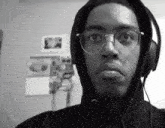 a black and white photo of a man wearing headphones and a hoodie