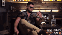 a man sitting in front of a bar that says fridays
