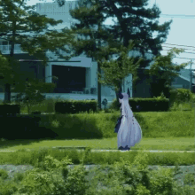 a woman in a white dress is standing in the grass