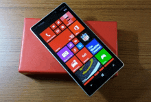 a cell phone with a nfl logo on the screen sits on a red box
