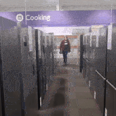 a man is walking down a hallway with a sign above him that says cooking