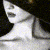 a black and white photo of a woman 's face and neck .