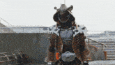 a person in a costume with a helmet and a belt with the letter r on it