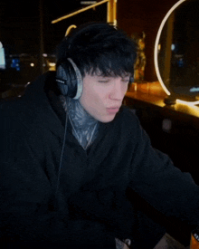 a man wearing headphones has a tattoo on his arm that says n.r.a.