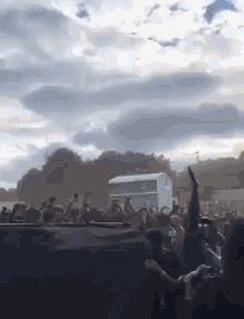 a crowd of people standing in front of a stage at a music festival