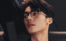 a close up of a man wearing glasses and a black shirt