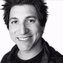 a black and white photo of a smiling young man