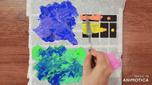 a person is painting on a piece of paper that says made in animotica on it