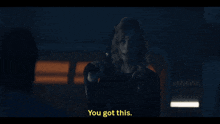 a woman holding a gun says " you got this " in yellow letters