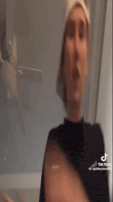 a woman is wearing a towel on her head and making a funny face .