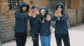a group of people standing in front of a wooden building with their hands in the shape of a heart with the letter a on them