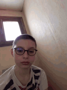 a young boy wearing glasses and a shirt that says ' a ' on it