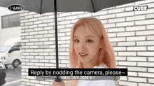a woman with pink hair is holding an umbrella in front of a brick building .