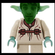 a lego figure with a green face and a red shirt